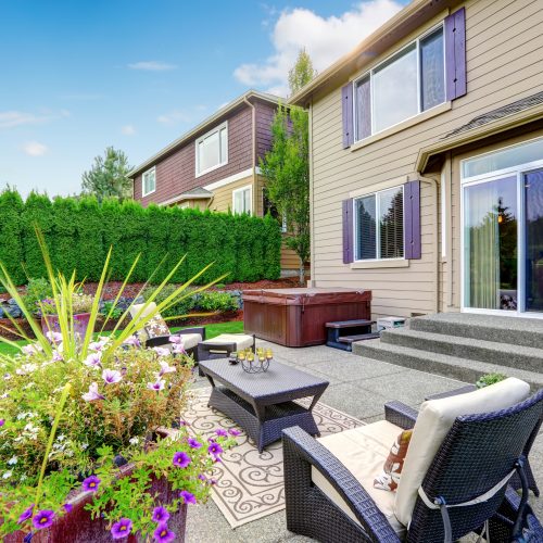 Cozy patio area with settees and table, decorated with flower pot