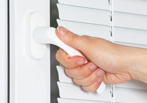 Hand opens the white plastic window with jalousie Hand opens the white plastic the window with jalousie